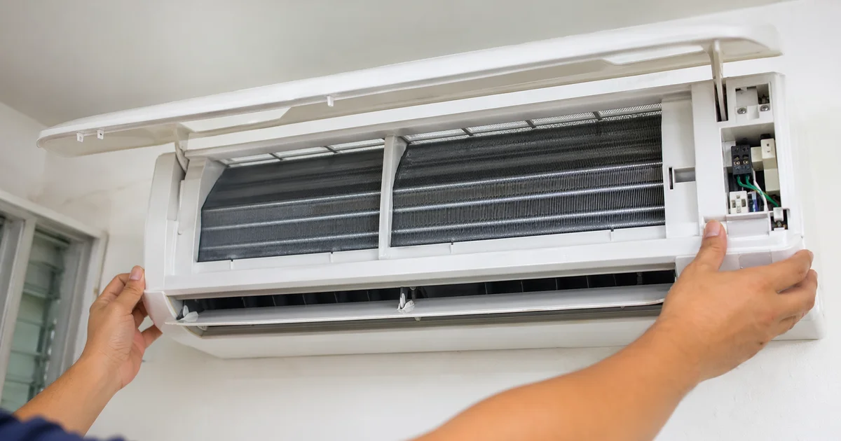 Wall-mount aircon with cover lifted showing restored coil