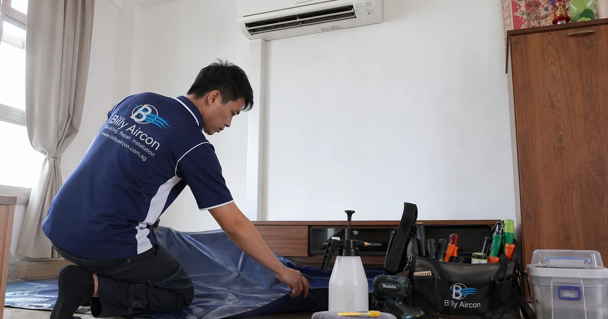 Aircon technician setting up tools beside HDB aircon for overhaul